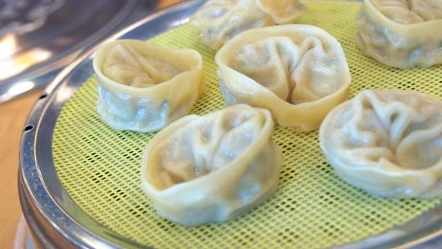 Steamed dumplings plated in a steamer on the table