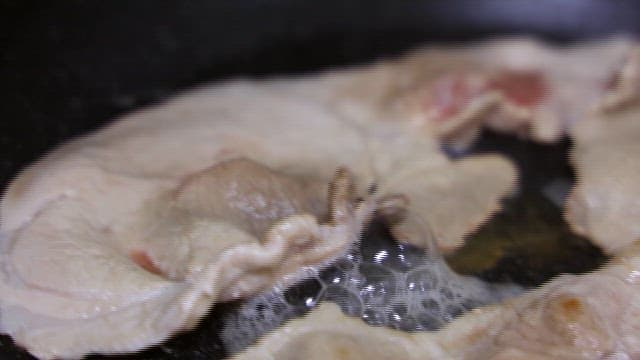 Pork Sizzling in a Frying Pan at Home