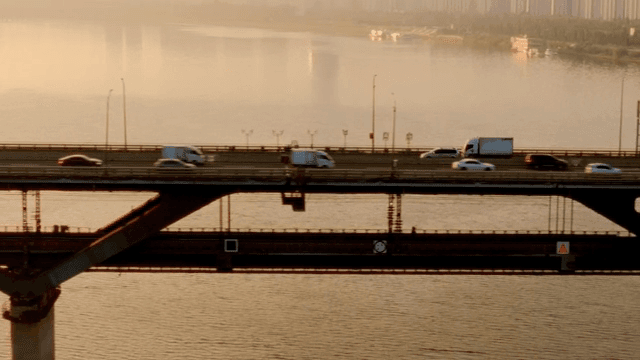 Cars crossing a bridge at sunset