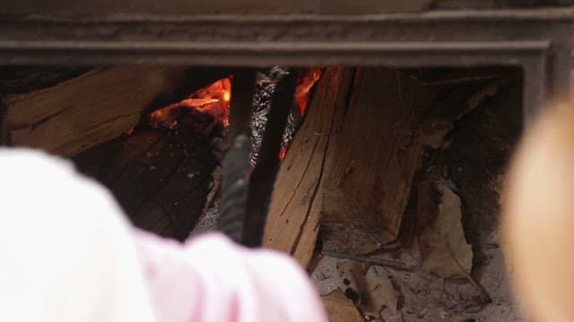 Baking sweet potatoes and potatoes wrapped in foil in the fireplace