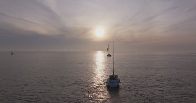 Sailboats on a calm sea at sunset