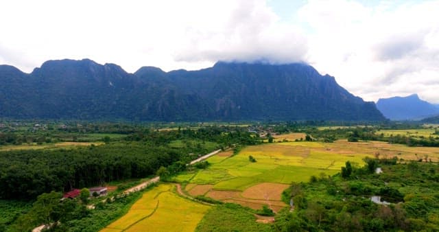 Aerial View of Lush Agricultural Land by Mountains