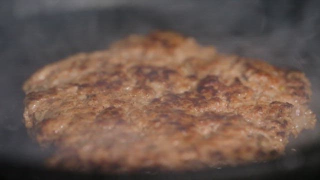 Juicy beef patty sizzling on a grill