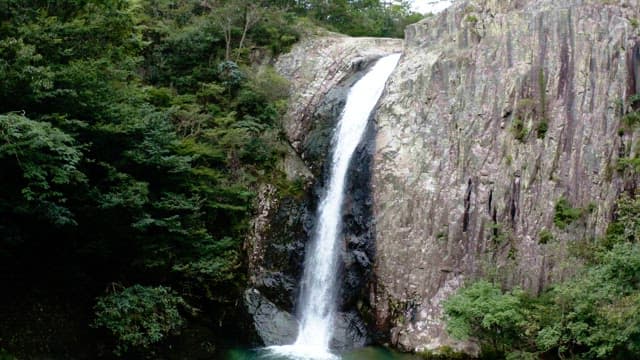 Majestic waterfall cascading between lush green cliffs