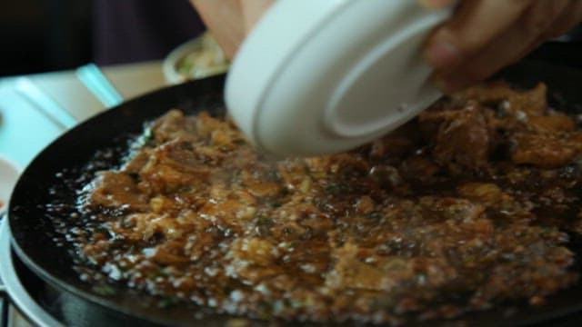 Person who puts garlic on sizzling meat