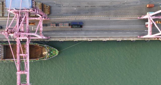Cargo ship docked at a port with cranes