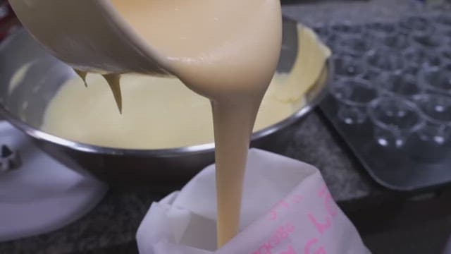 Pouring creamy bread batter into a piping bag
