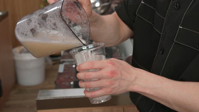 Pouring Fresh Korean Melon Juice into Glasses on a Kitchen Counter