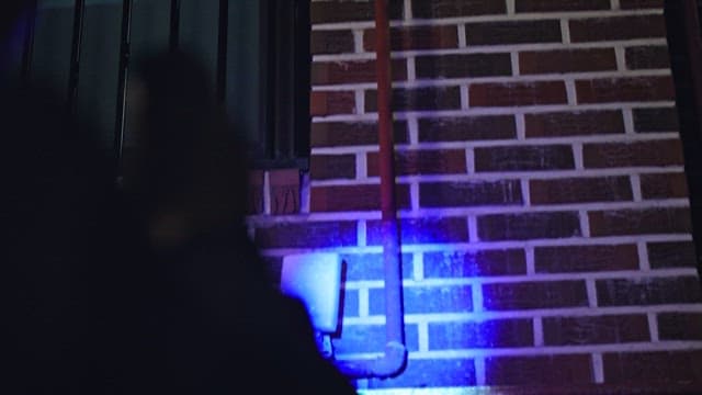 Blood Stains Appearing on the Wall Illuminated by UV Light.