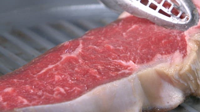 Grilling a juicy beef steak on a hot pan