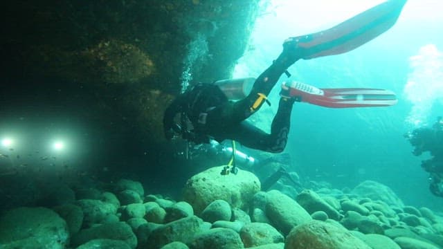 Scuba Divers Exploring Underwater Cave