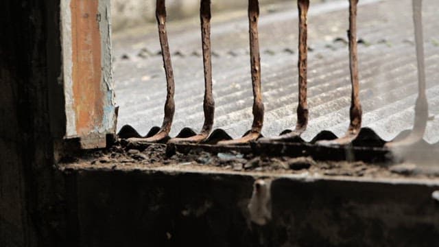 Rusty old metal bars on a window in an abandoned building