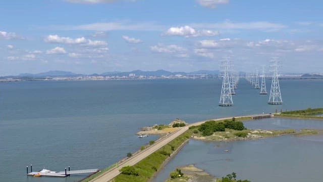 Coastal Area with Electric Towers and Clear Skies