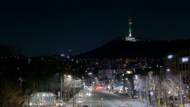 Night view of a city street with a tower