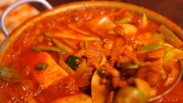 Spicy pork stew with tofu and vegetables boiling in a pot