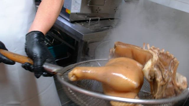 Rinsing boiled pig's feet and meat in water in the kitchen