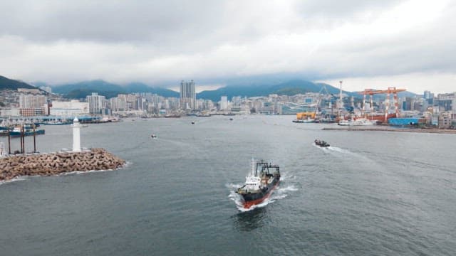 Ship passing near a foggy city harbor