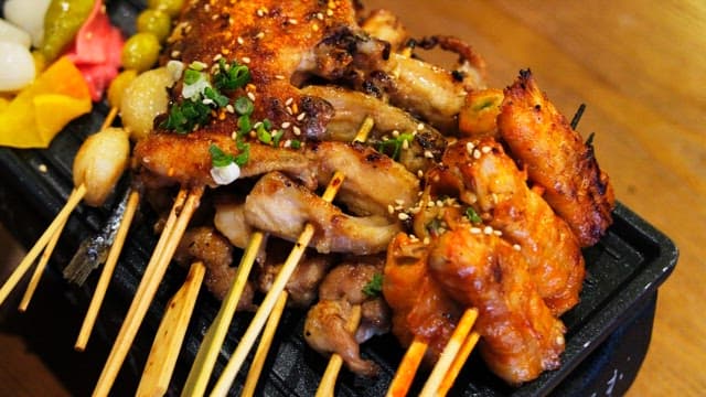 Various types of grilled skewers neatly arranged on an iron plate