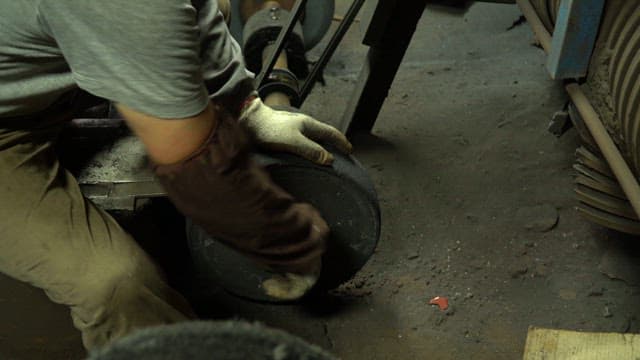 Worker handling machinery parts in a factory