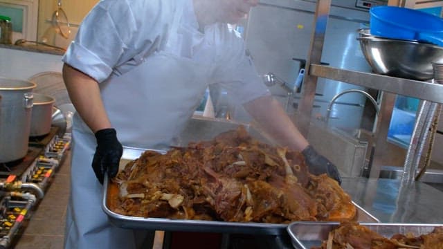 Steamed meat pieces on a metal tray in a kitchen