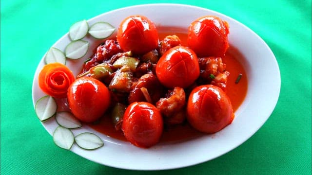 A Plate of Tomatoes and Chicken in Sauce