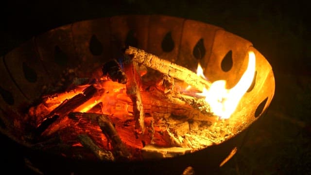 Logs burning brightly in a fire pit during the night