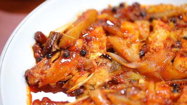 Spicy braised fish in a white bowl