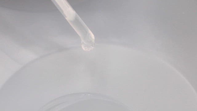 Pipette Dropping Liquid on a Transparent Plate