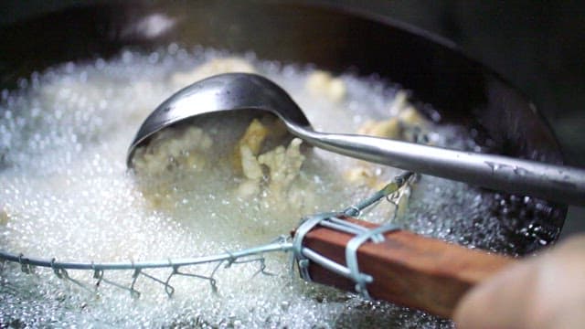 Fried pork for sweet and sour pork being cooked in hot oil