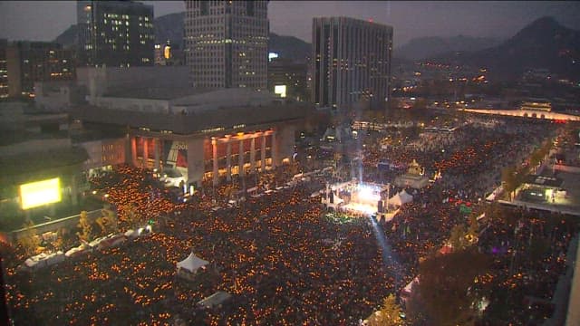 City square packed with people at dusk
