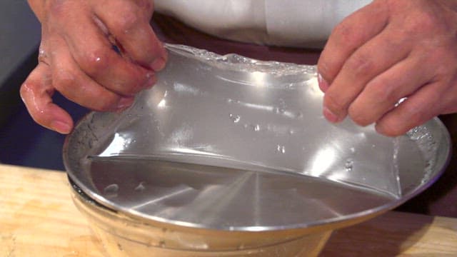 Chef removing cooked starch batter from a tray