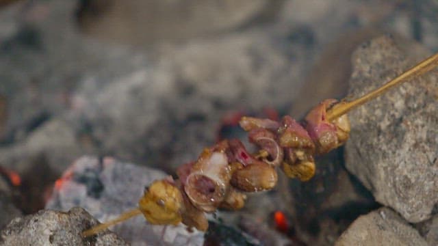 Skewered tuna grilling over hot coals