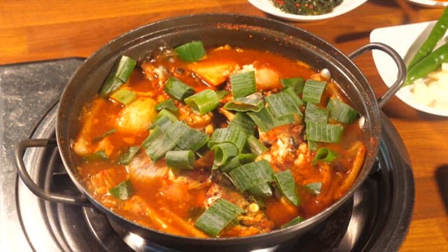 Delicious Pot of Spicy Fish Stew Garnished with Fresh Green Onions