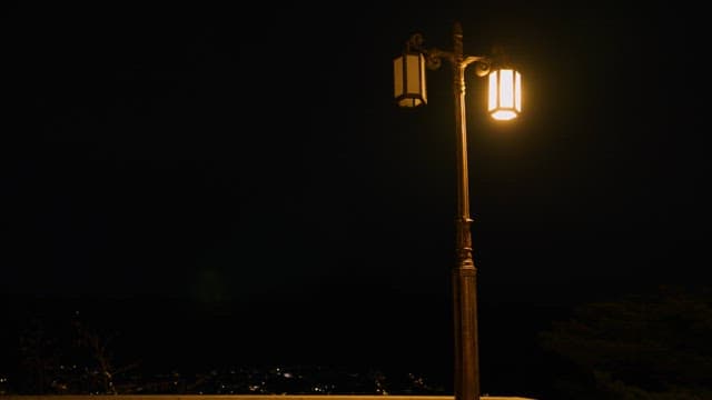 Solitary figure under a streetlamp at night