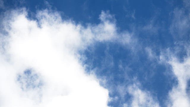 Clear blue sky with scattered white clouds