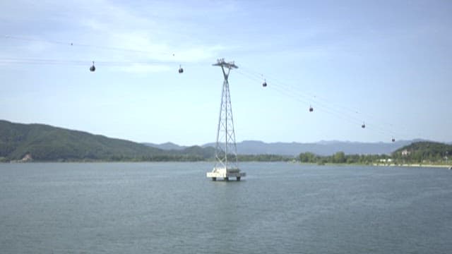Paddle Boarders on Scenic River under Cable Cars