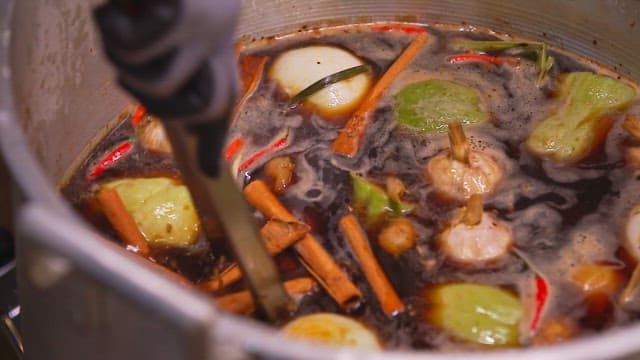 Boiling vegetables and spices in a large pot to make broth
