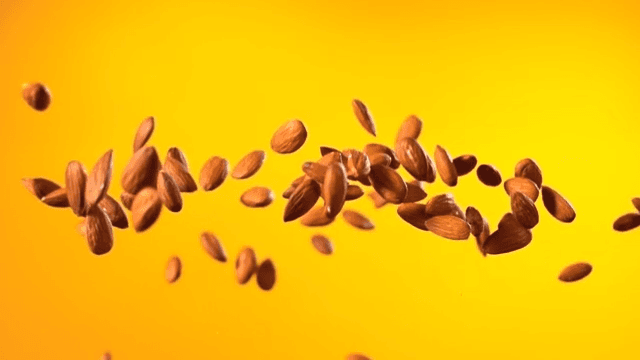 Almonds floating against a yellow background