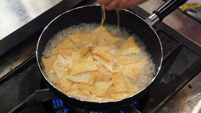 Fish cakes boiling in a pot on a stove