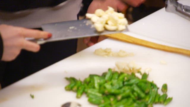 Add minced garlic to pork stir-fry cooked in a pan