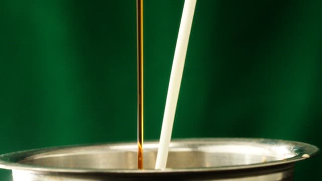 White milk and brown coffee poured against a green screen