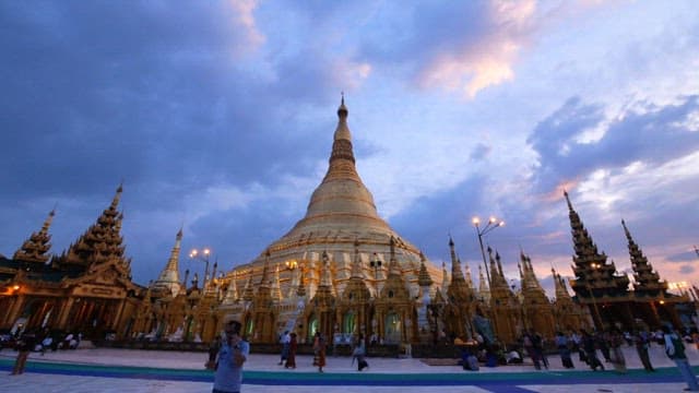 Visitors walking around Shwedagon Pagoda from day to night