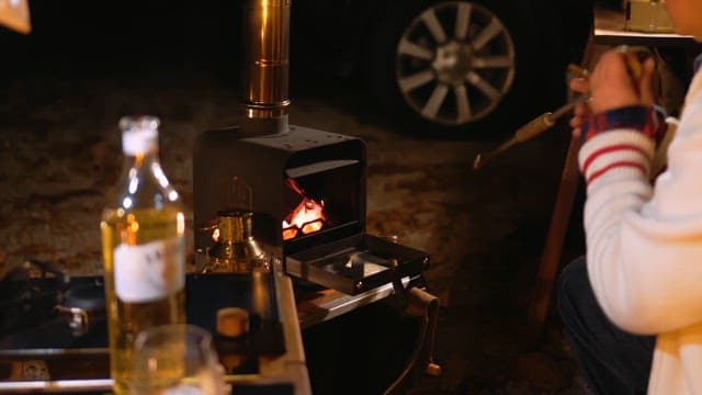 Person Blowing Air into Firewood to Make Big Flame
