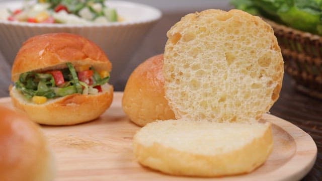 Making a sandwich by spooning fresh coleslaw onto bread