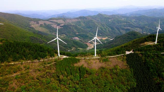 Wind turbines on a lush green mountain range