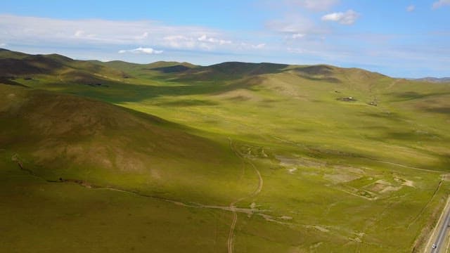 Expansive green hills under a blue sky