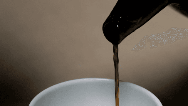Pouring soy sauce into a cup