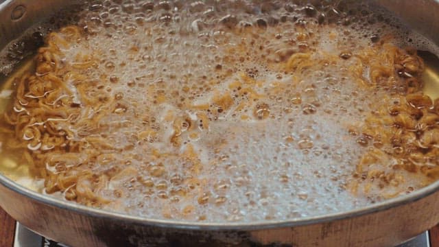 Ramen noodles boiling in a pot