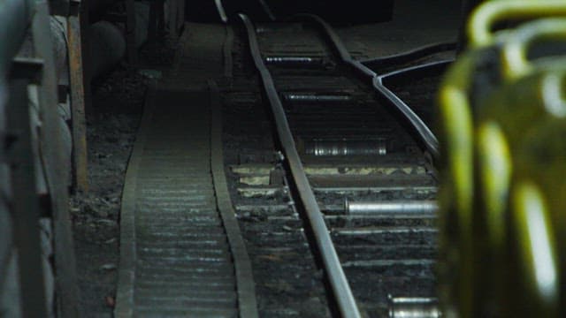 Mine tunnel with railway tracks and pipes