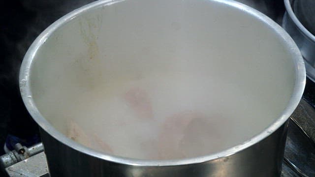 Steaming broth made by boiling pork bones and skulls